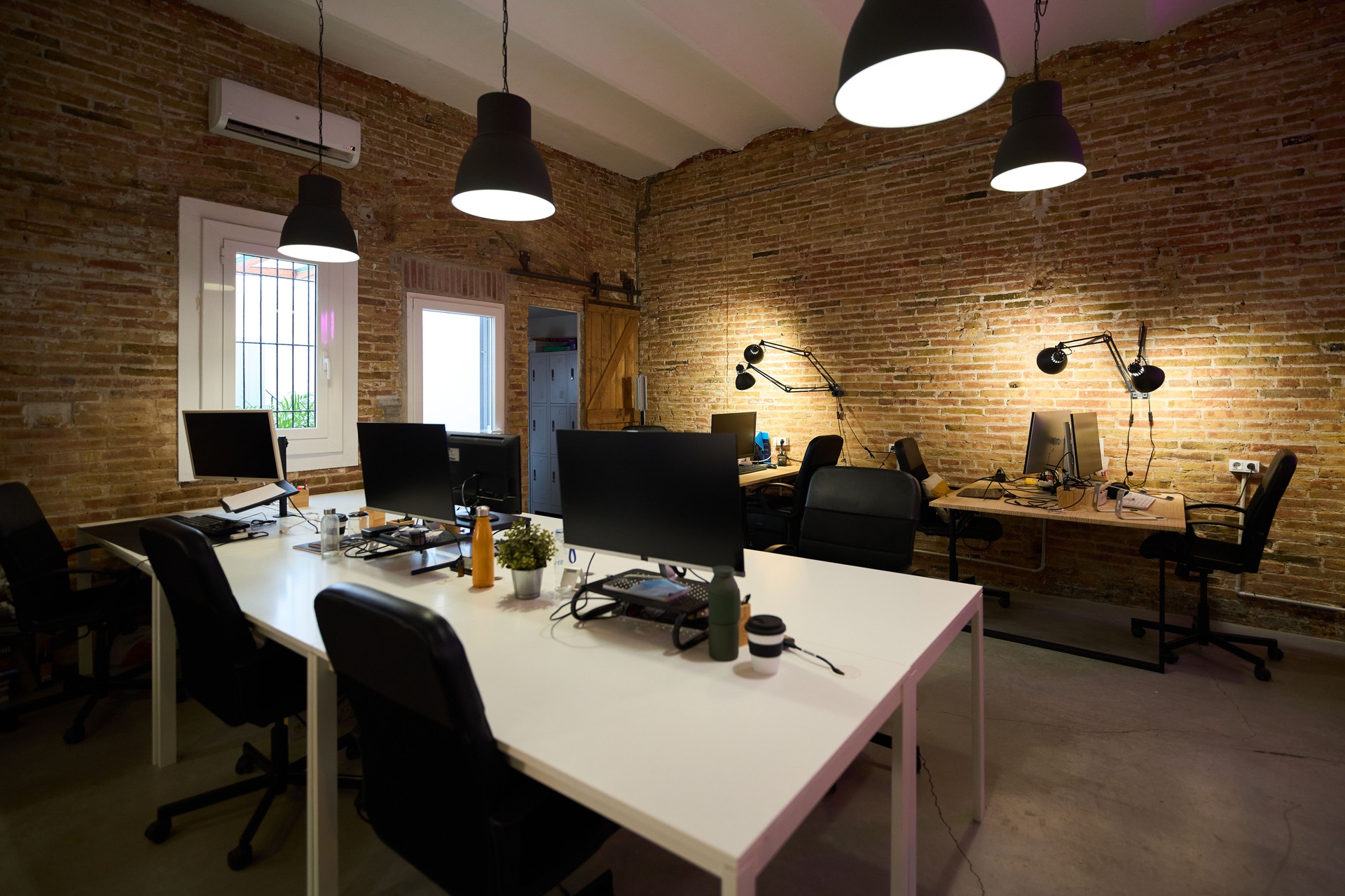 Modern coworking space with exposed brick walls and stylish lighting